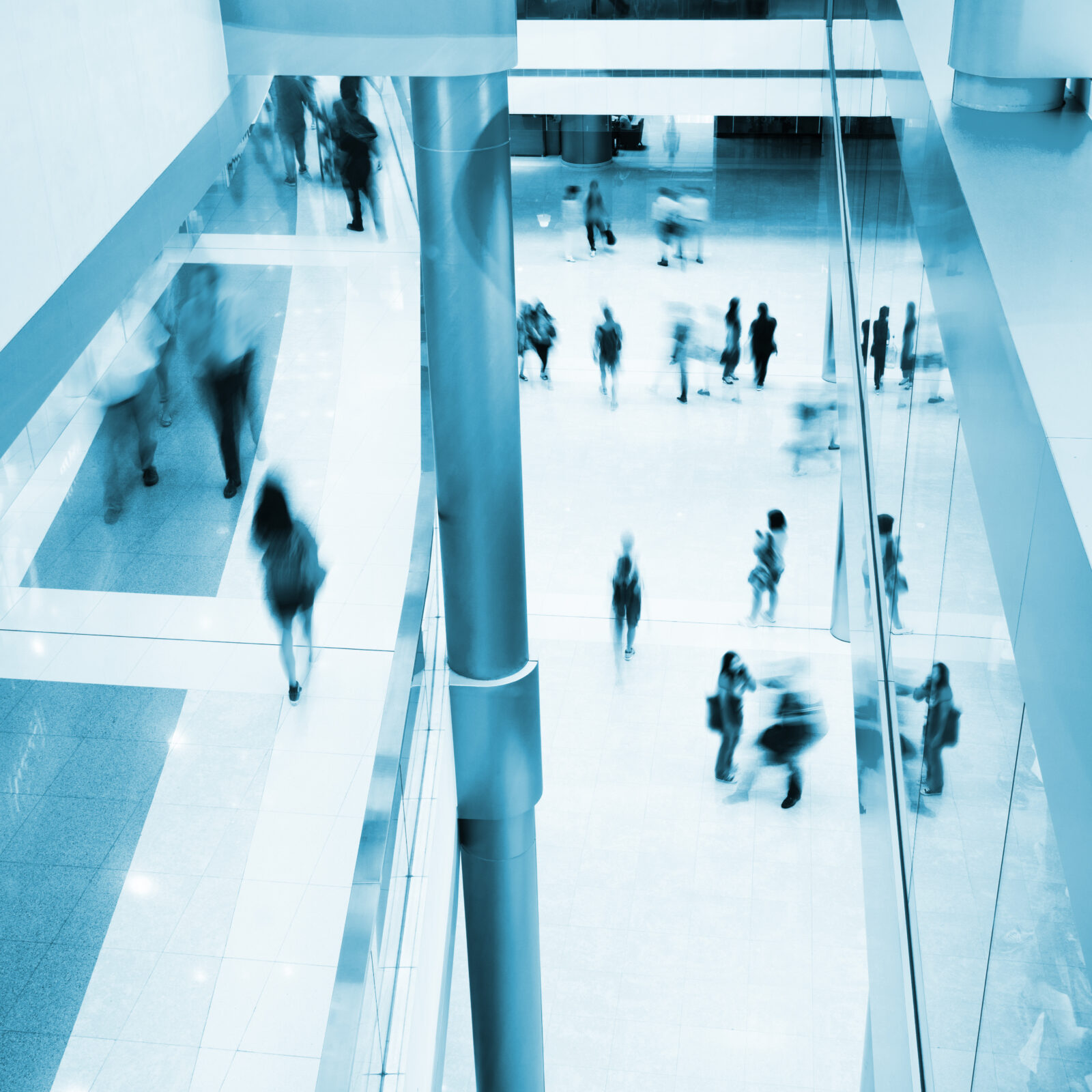Blurred people rushing in an office lobby