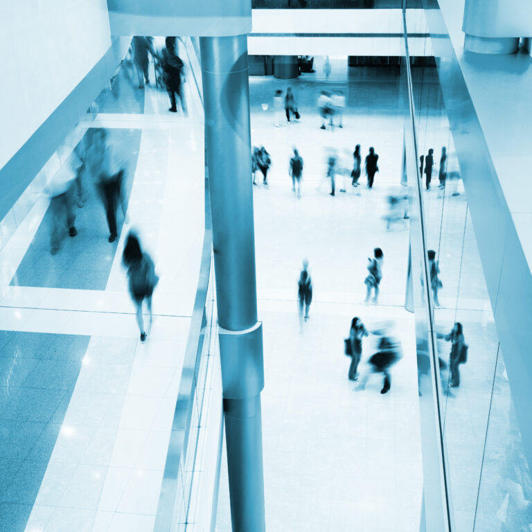 Motion blurred people rushing in an office lobby