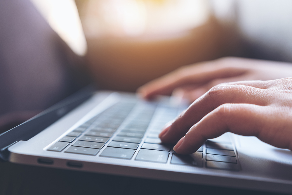 close hand typing on a keyboard
