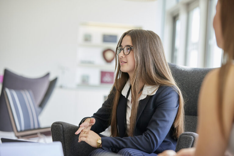 person in a suit sat in a reception waiting area in an office