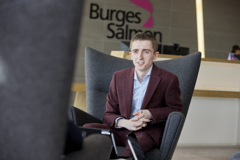 person in a suit sat in a reception waiting area in an office