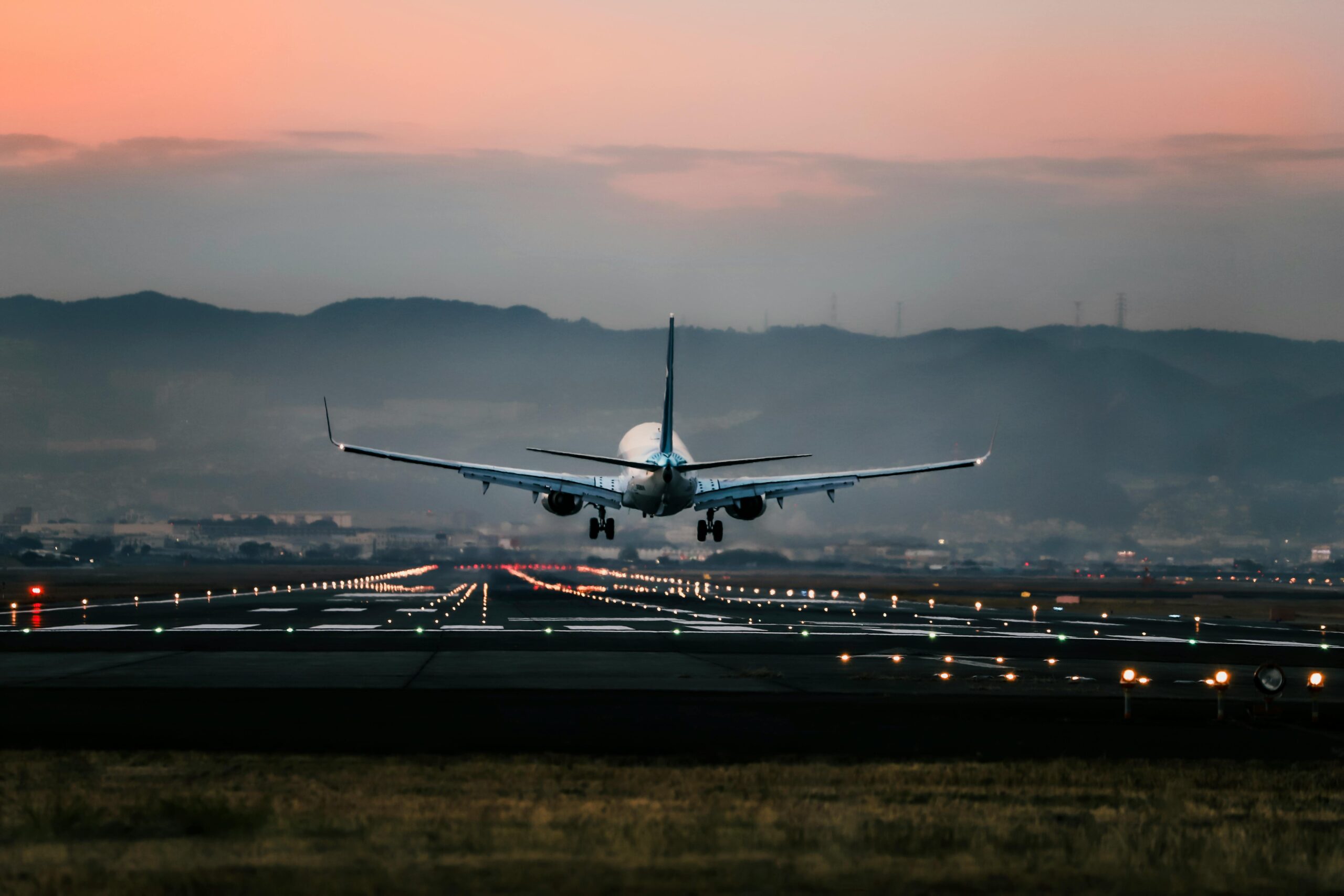A commercial plane taking off at sunset