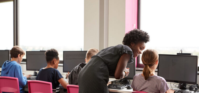 Female Teacher Supervising Line Of High School Students Working