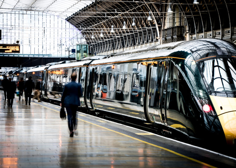 Train Station Platform With Motion Blurred People Walking representing the transport sector