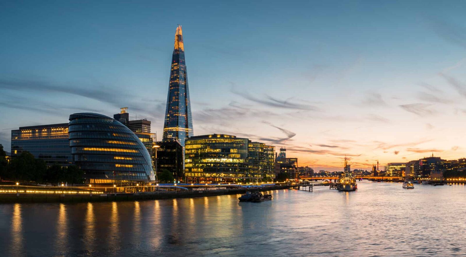 A photo of London by night, looking at the Shard beyond the river Thames