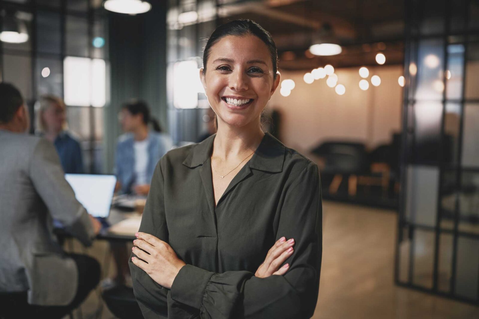 Female employee looking at camera with a soft-focus open plan background