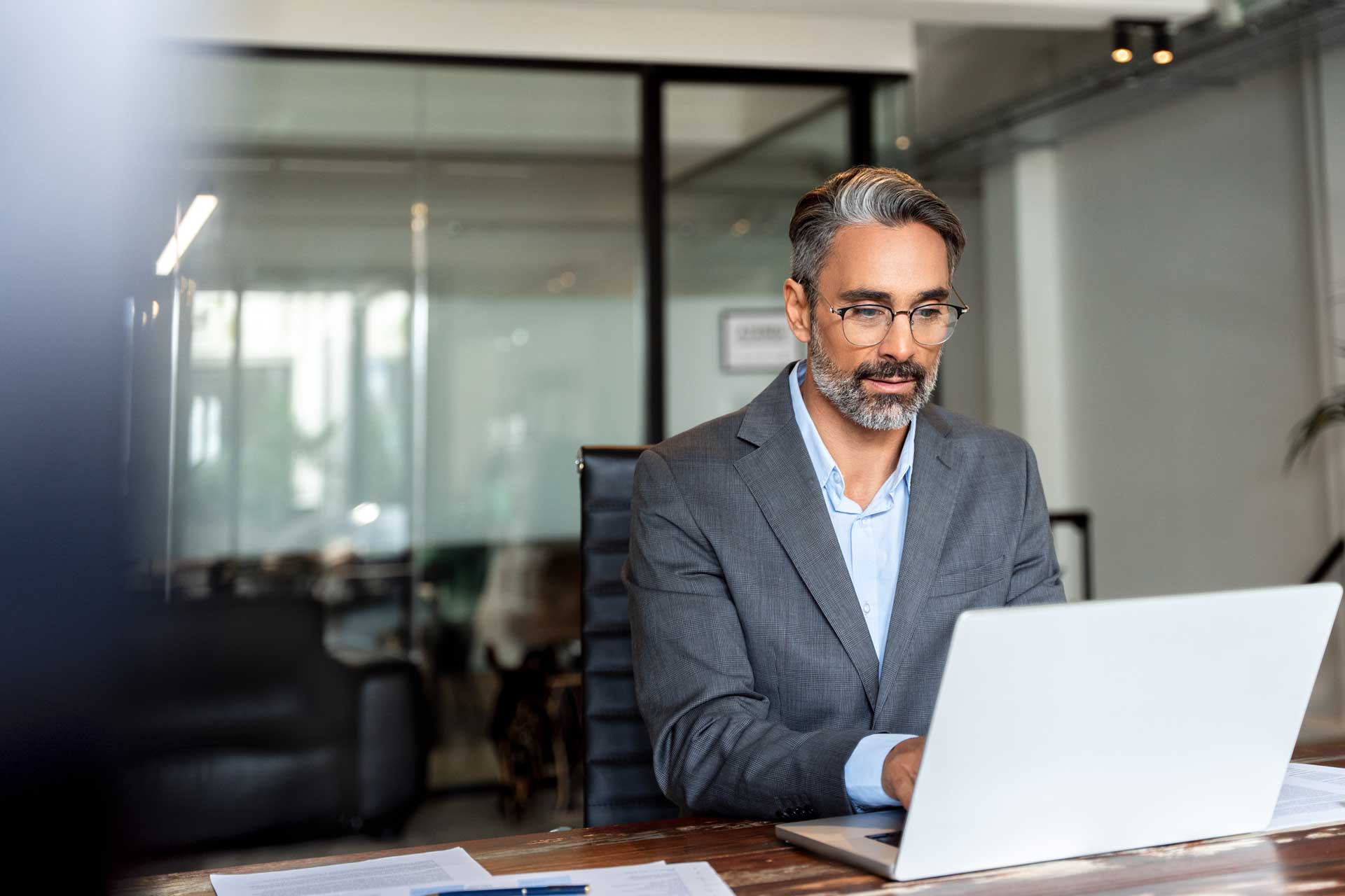 Man in suit on laptop in single office