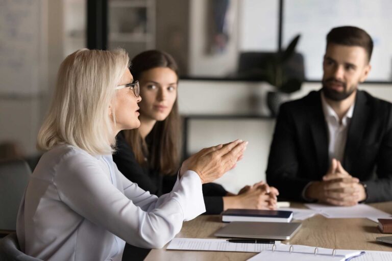 Three employees discussing matters in open plan meeting