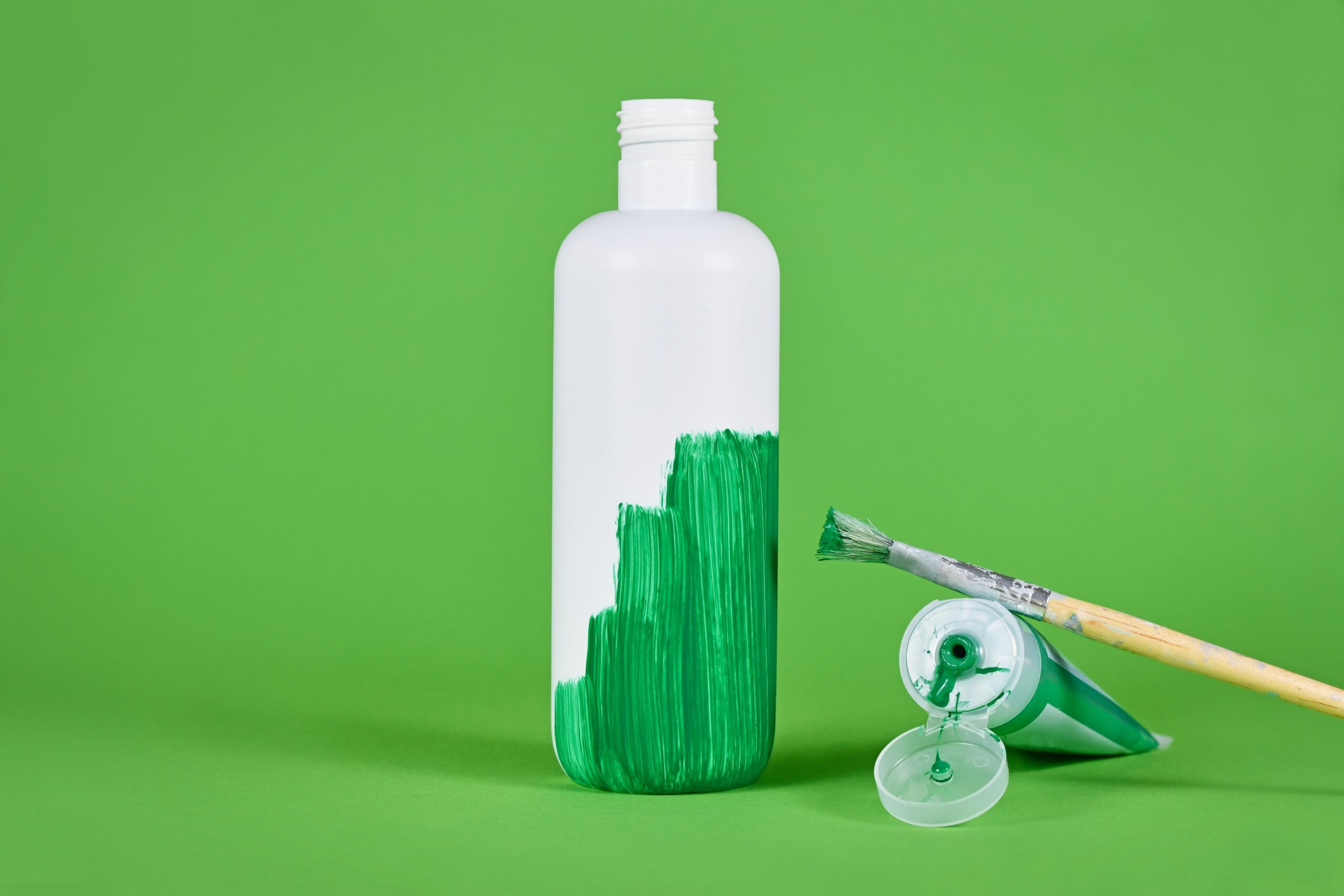 White plastic bottle being painted green