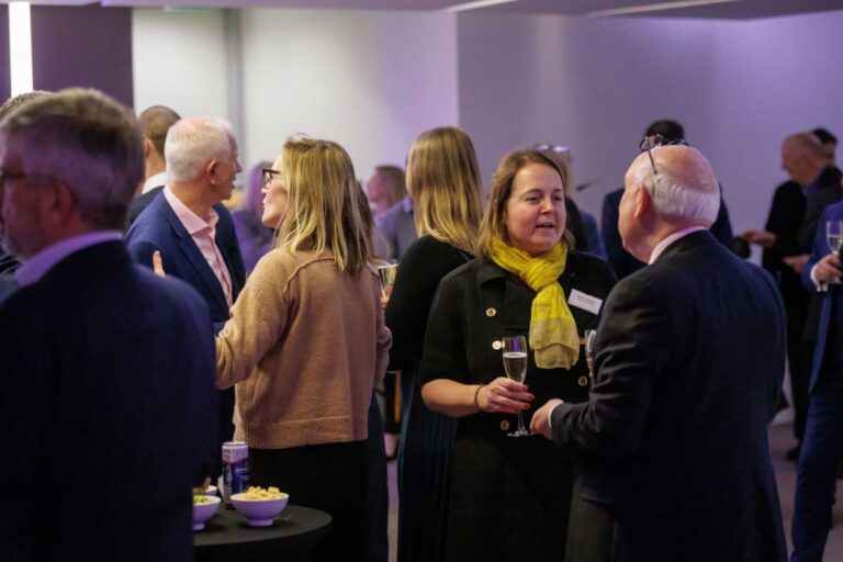 Burges Salmon employees at an event, standing in discussions