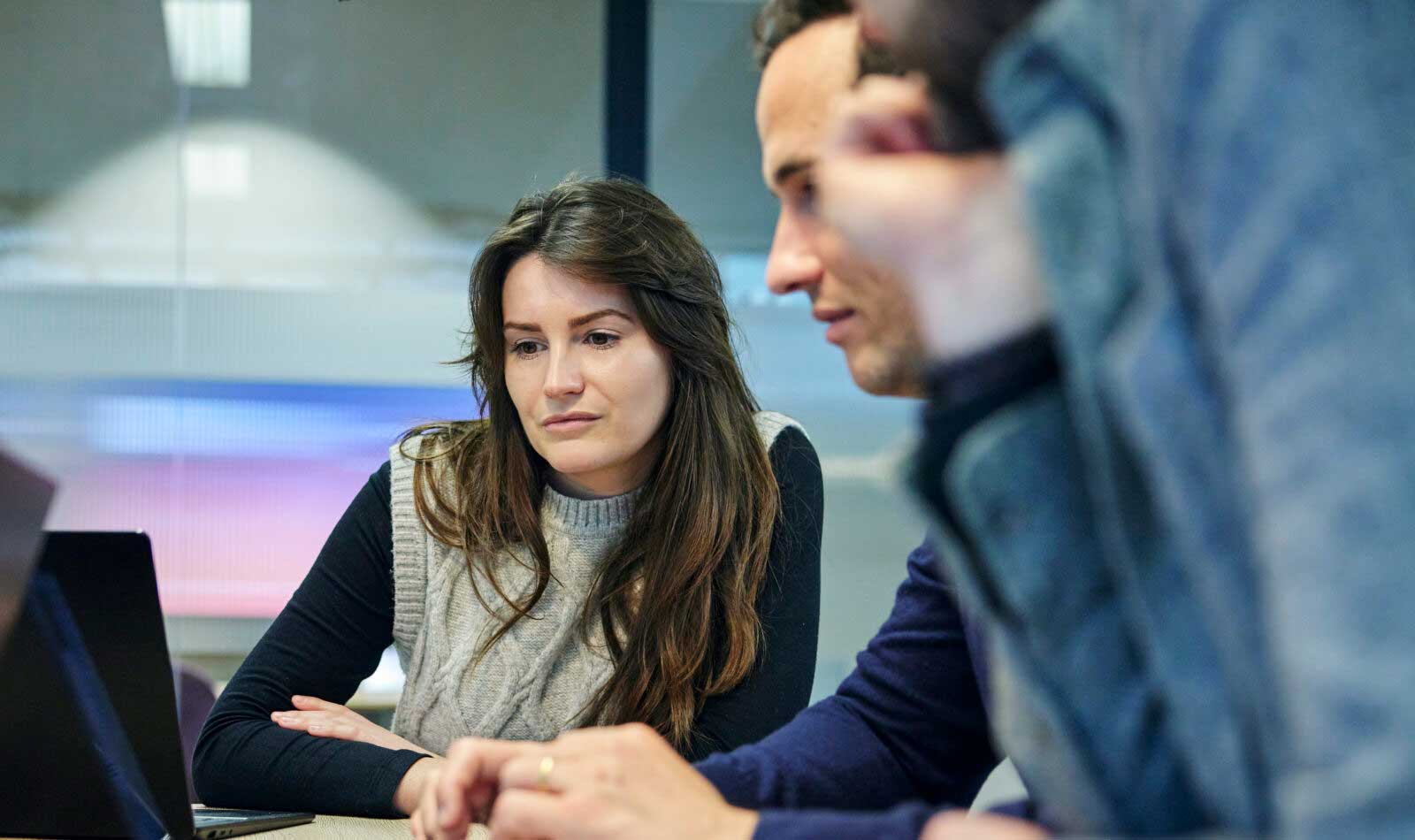 Three Burges Salmon employees in a meeting looking at a laptop