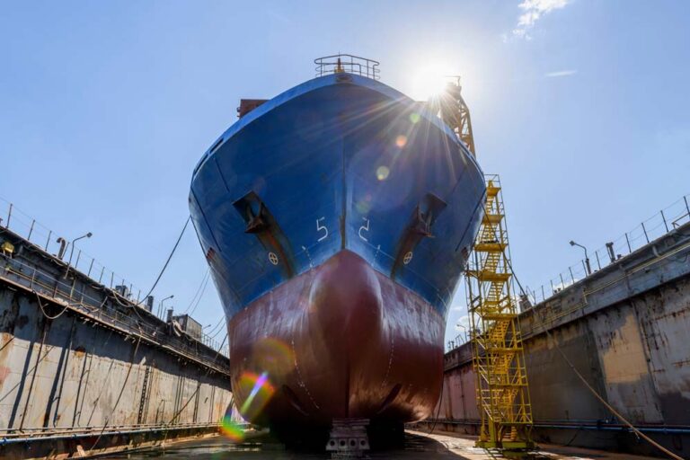 Large cargo vessel positioned in a dry dock for maintenance and repair
