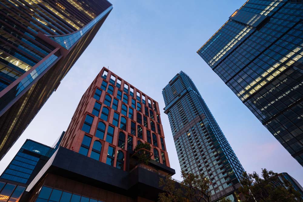Looking up at modern office buildings against evening sky