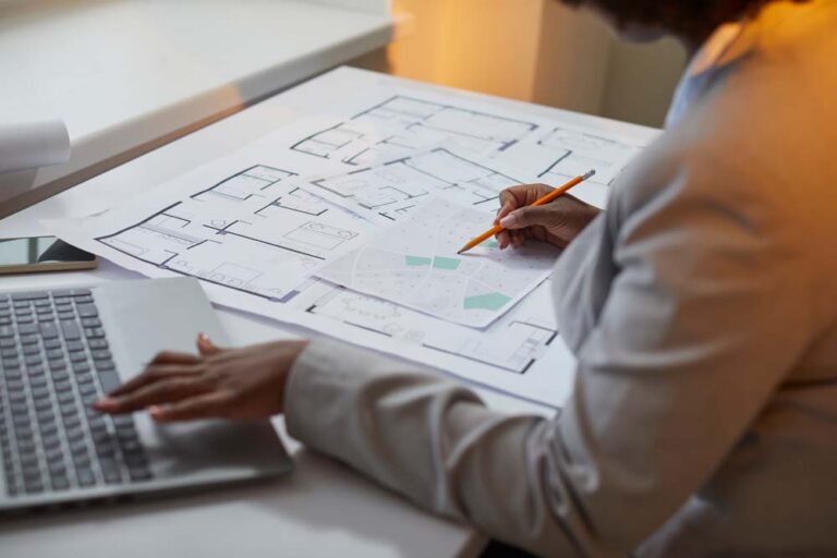 Person reviewing land development plans at a desk