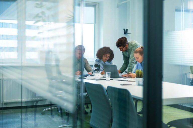 Employees collaborating around a table in a modern office meeting room
