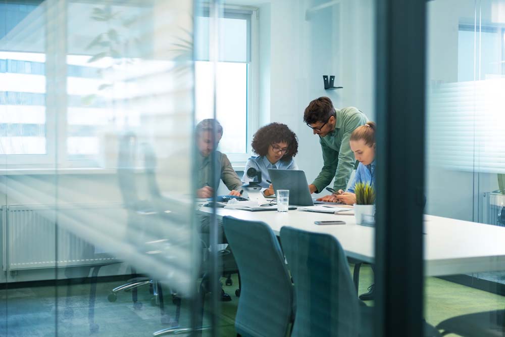 Employees collaborating around a table in a modern office meeting room
