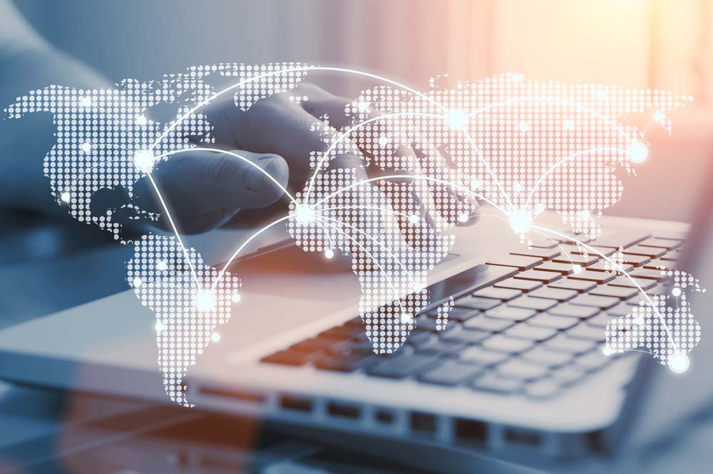 World map with digital network connections over a laptop keyboard